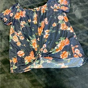 Knit floral top with buttons and knot at bottom front.